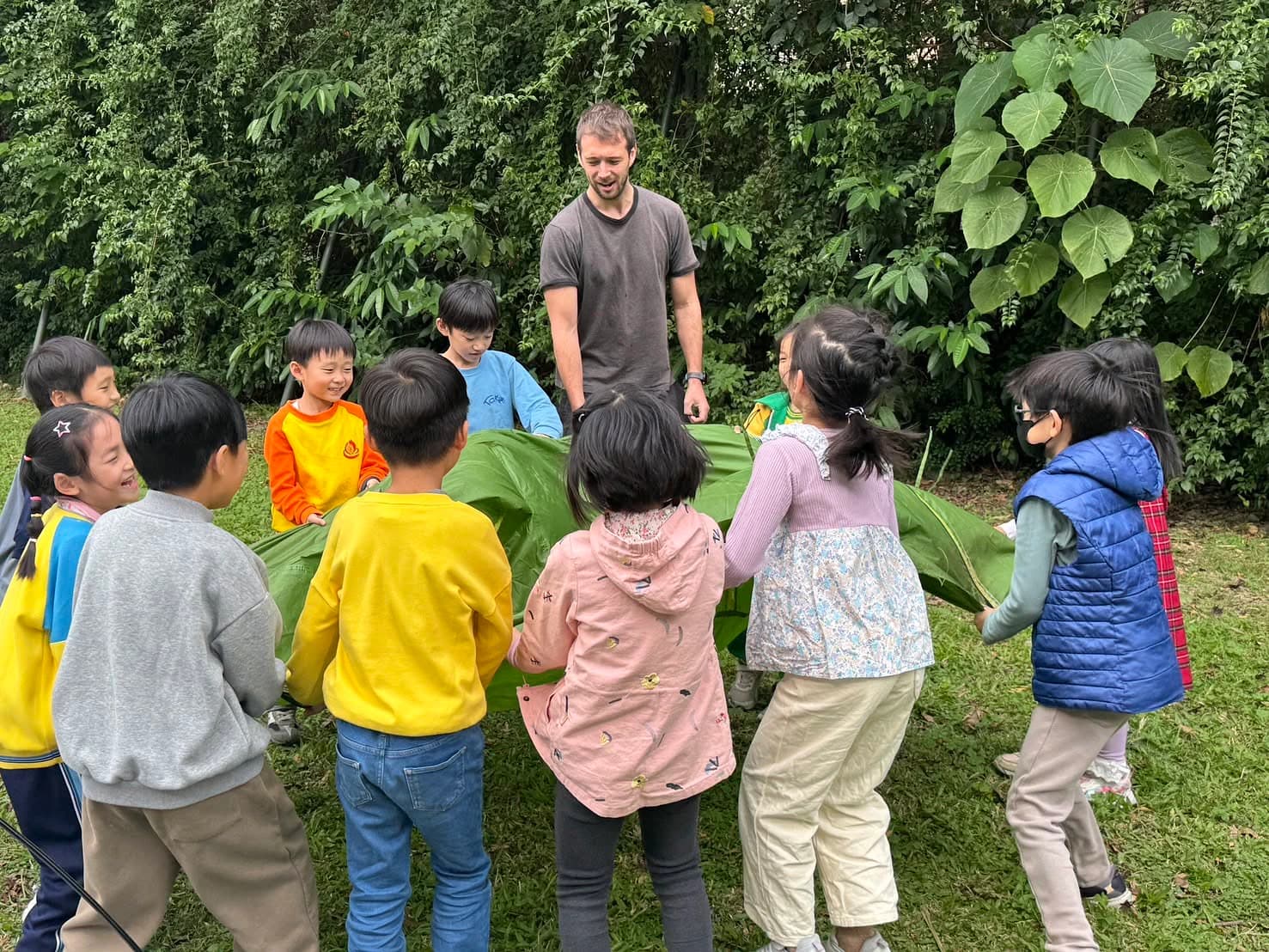 Teacher supervising students during an outdoor after-school activity / 老師帶領學生進行戶外課後活動