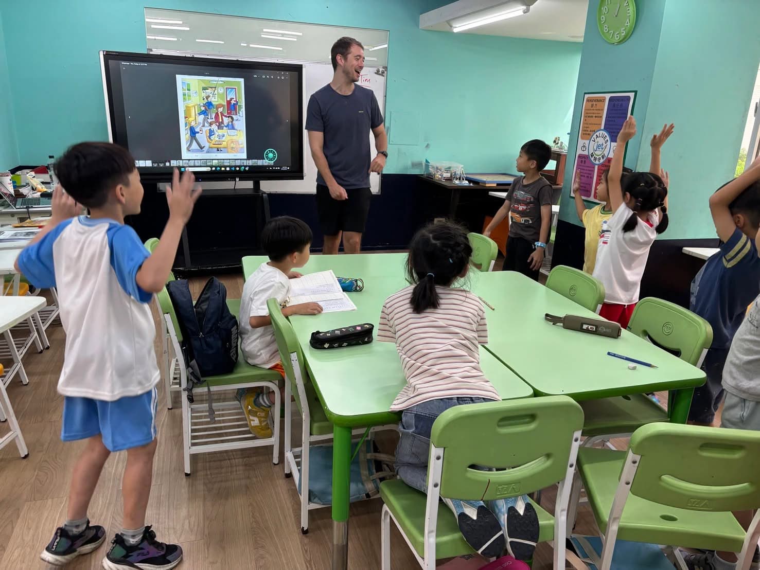 Students listening and raising their hands during English class / 學生在英語課堂中聆聽並舉手參與